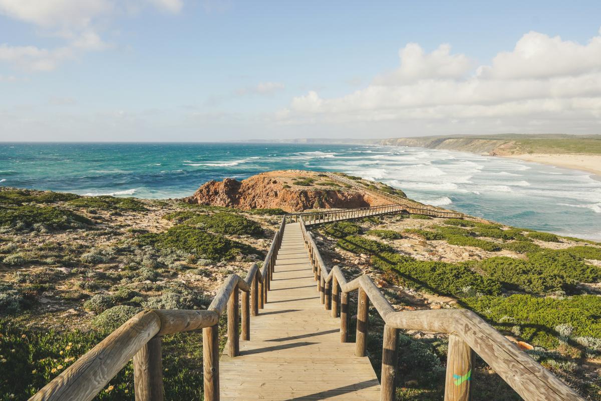 A photo of a walkway leading to a rugged beach near Faro, Portugal