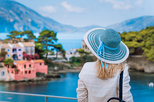 A woman looking at trees, a body of water, and houses